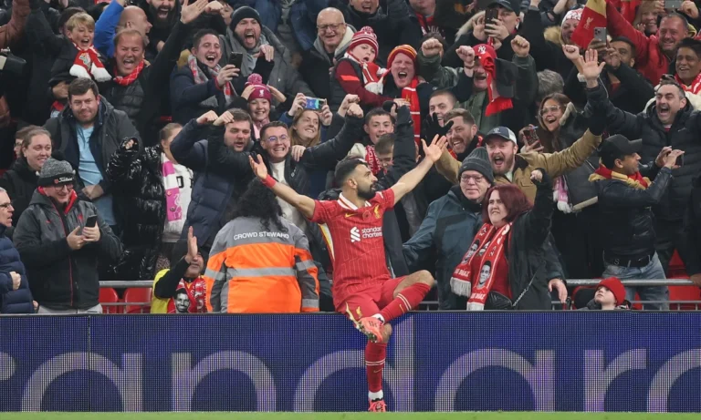 Joueur de Liverpool célébrant un but devant le système LED périmétrique, tribune en liesse