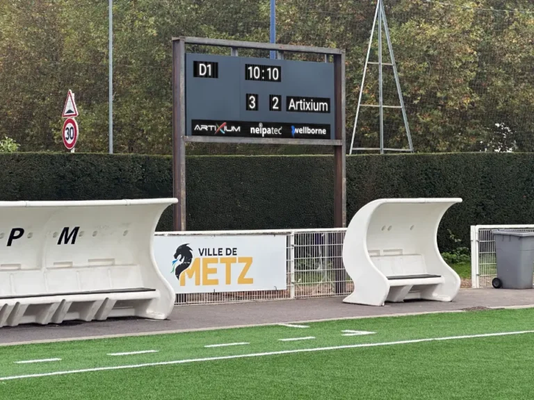 LED scoreboard beside the synthetic pitch, team shelters and a Ville de Metz banner
