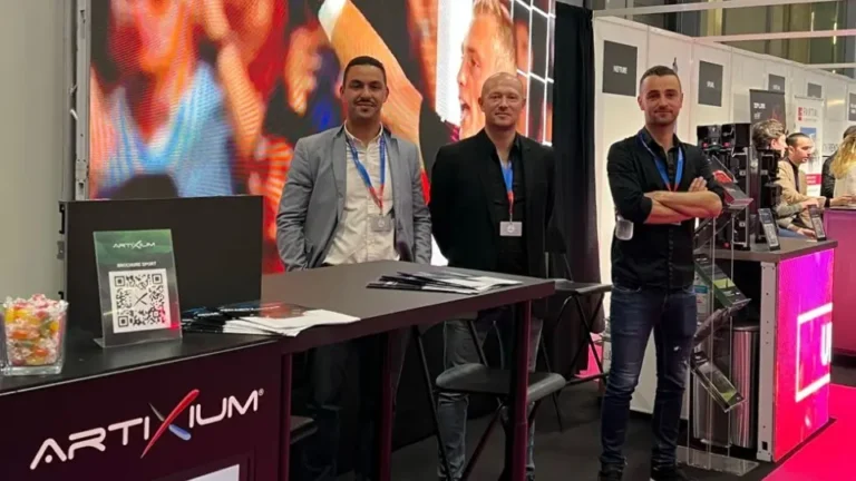 Heavent Paris 2022 : trois membres de l'équipe derrière le comptoir du stand devant un grand écran LED