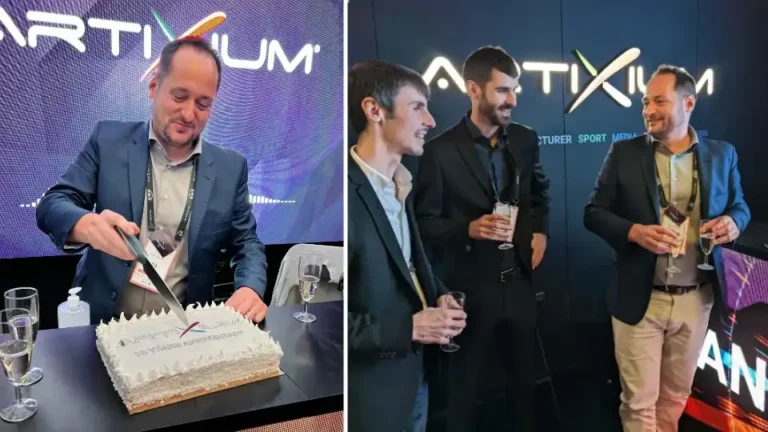Homme découpant un gâteau anniversaire Artixium et collègues trinquant devant le mur LED du stand