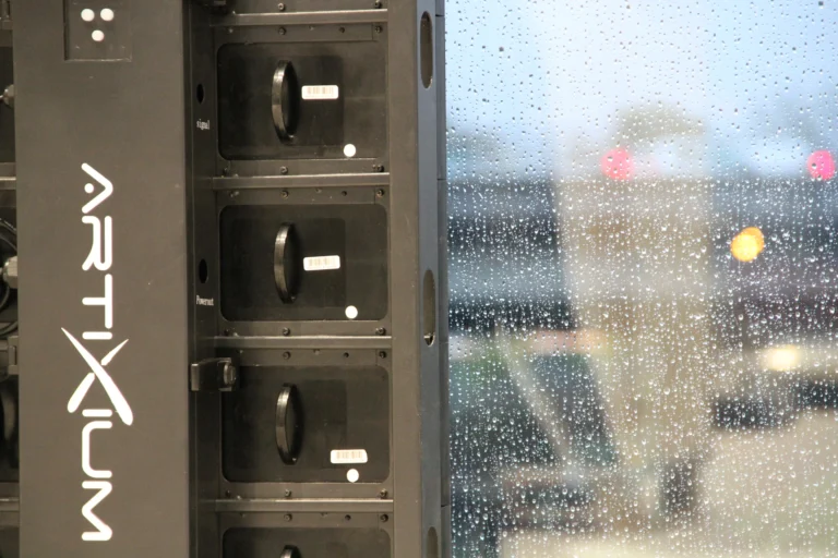Détail d’une dalle LED Artixium : connecteurs signal et alimentation, vitre ruisselante de pluie