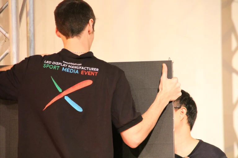 LED screen church – Technician in an Artixium polo fitting an IRON LED cabinet onto the installation structure