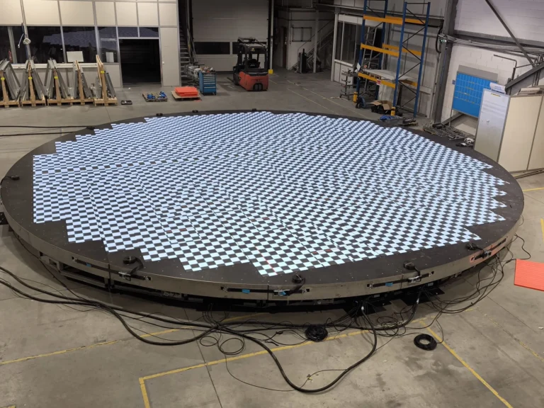 Circular LED floor assembled in the workshop, displaying a checkerboard test pattern