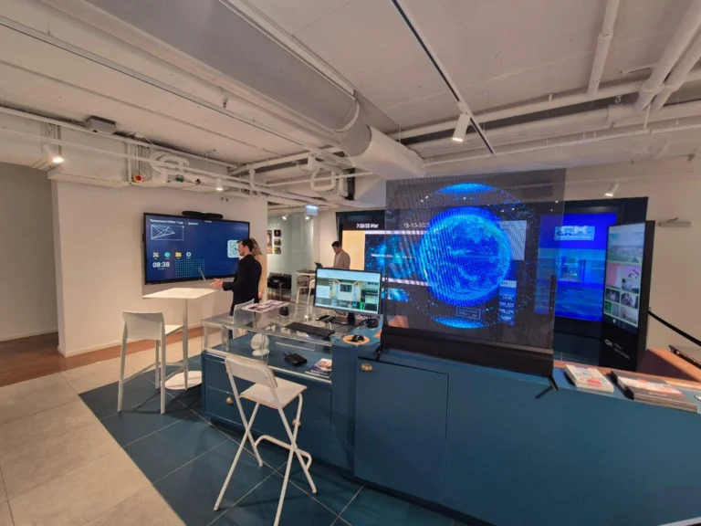 Écran LED transparent diffusant un globe bleu au-dessus d'un comptoir dans un espace de démonstration