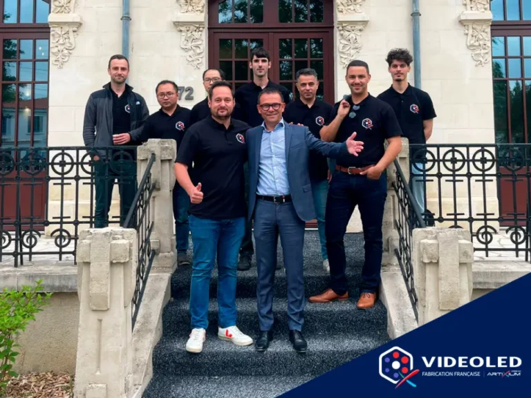Cocktail Vision : équipe en polo noir sur les marches de l'usine, logo Videoled incrusté