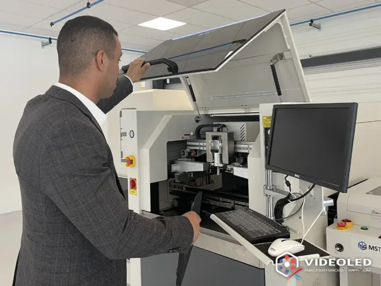 Homme en costume ouvrant le capot d'une machine de placement de composants électroniques