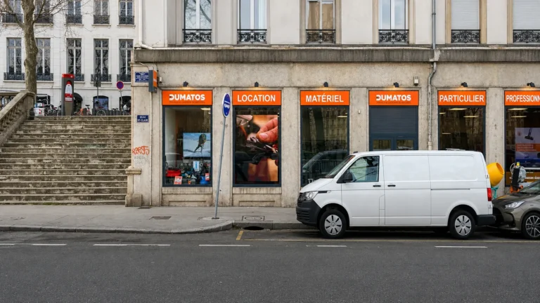 Store frontage on the quayside with vertical LED screens in the windows and a van parked outside