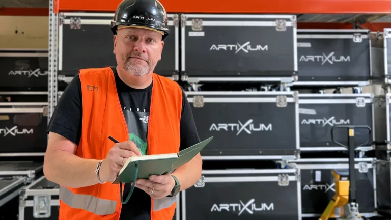 Logistics manager holding a notebook in front of Artixium flight cases
