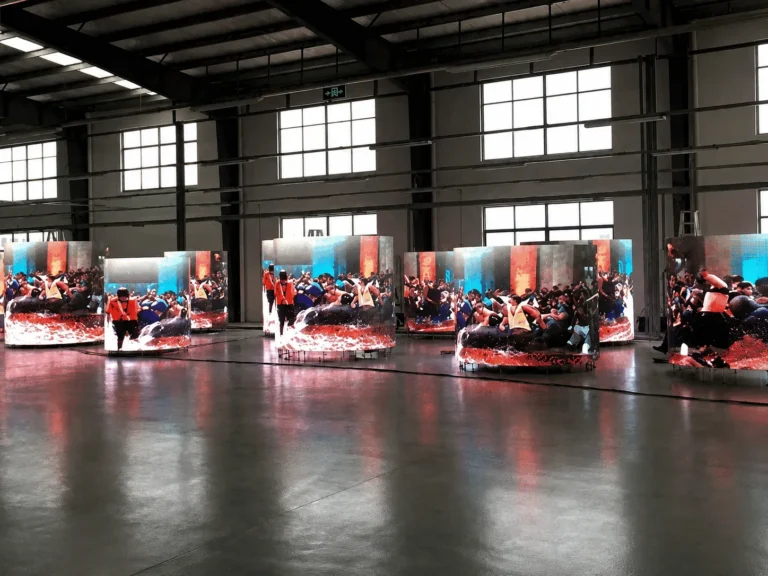 LED screen shopping centre – Curved LED columns under test in an assembly hall, a crowd image running across them