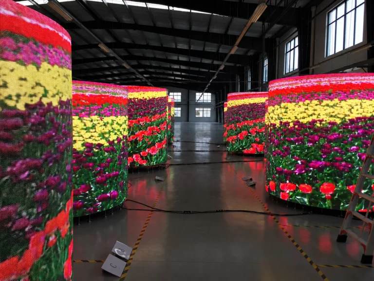 HYDROGEN LED cylinders showing a tulip field, lined up in the pre-assembly hall