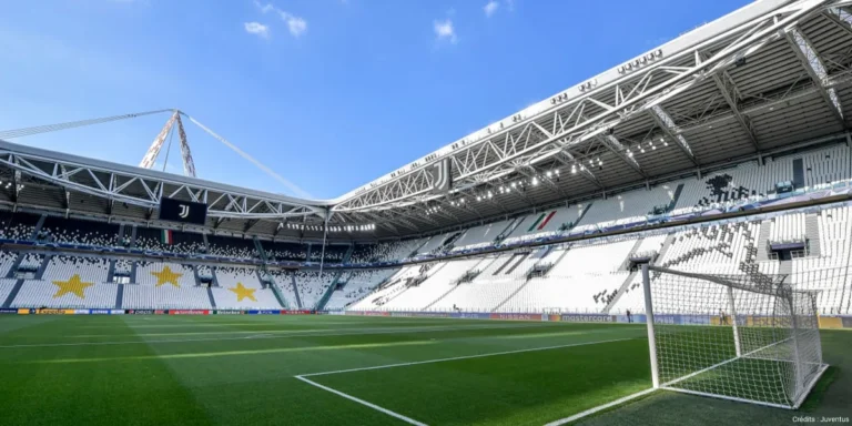 Empty stadium under a blue sky, perimeter LED system running across the far side behind the goal