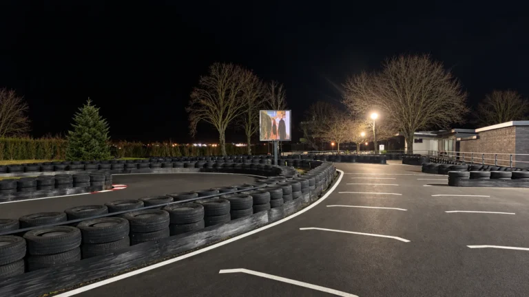 Piste de karting éclairée la nuit, écran LED COBALT diffusant un visuel au bord du circuit