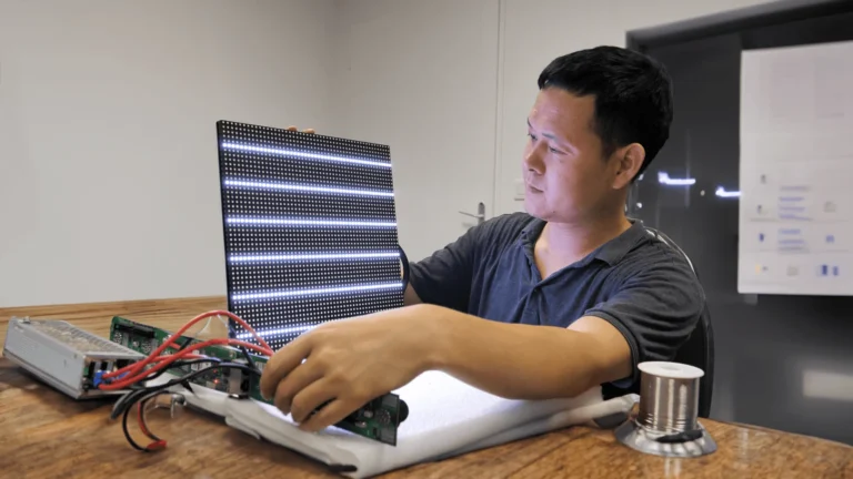 Engineer testing a powered LED module on the lab test bench