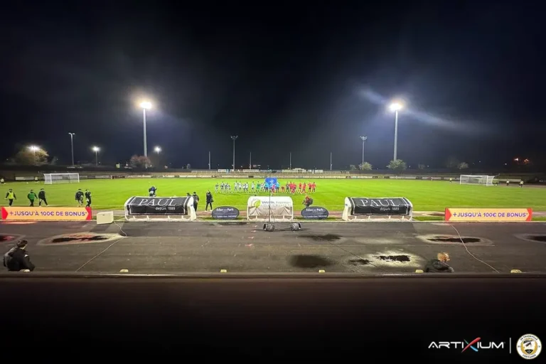 Vue nocturne d'un stade de football avec système LED périmétrique allumé autour des bancs de touche