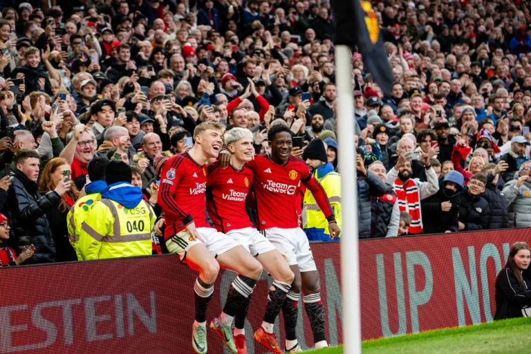 LED screen stadium Old Trafford – Three Manchester United players sitting on the lit perimeter LED system, crowd going wild