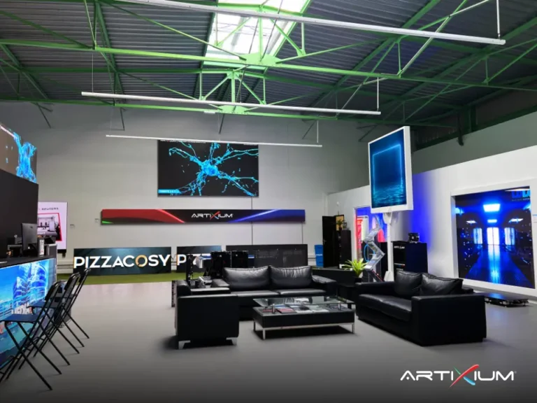 Lounge area with black sofas surrounded by wall LED displays and a curved LED banner