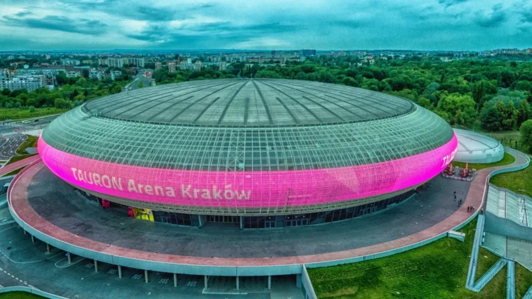 Écran LED stade Tauron Arena – Vue aérienne de la Tauron Arena Kraków, façade LED rose en anneau affichant le nom de la salle