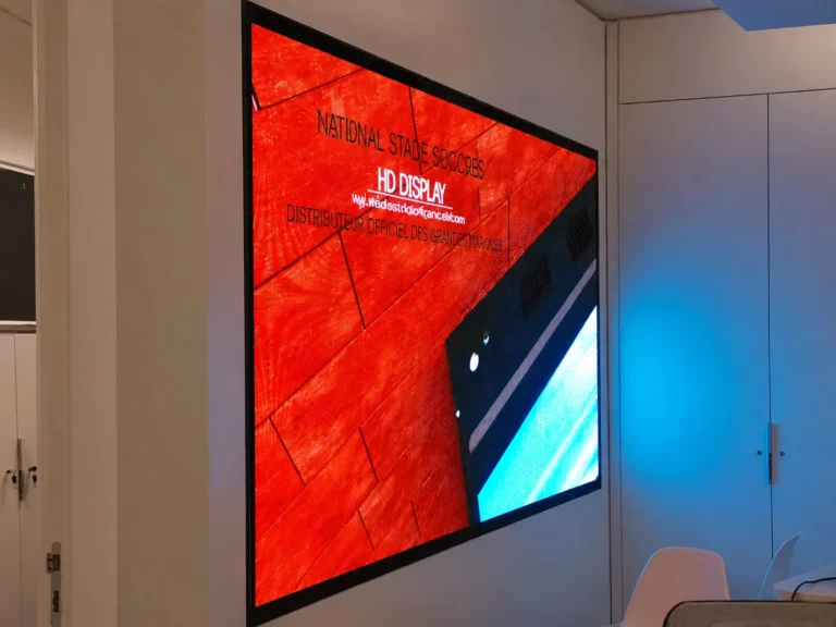 Indoor LED video wall seen at an angle in an office, a full-surface red visual on pale walls