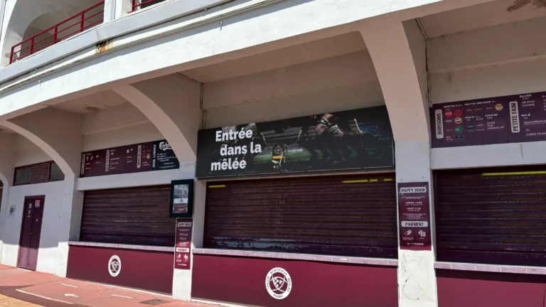 Bandeau LED au-dessus d’un point de vente du stade, coursive déserte en plein jour