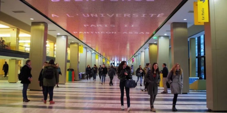 LED screen university – Red LED ceiling running text above the university concourse, students walking beneath