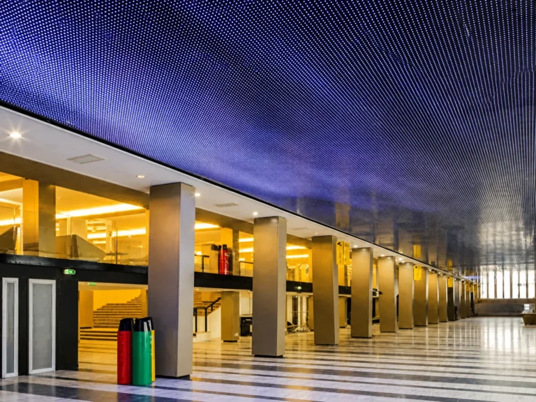 Long blue LED ceiling stretching above the empty colonnaded concourse