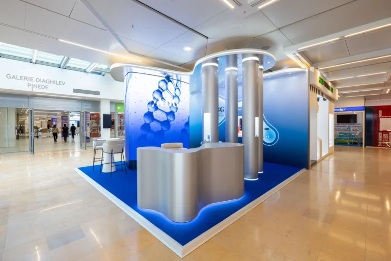Animated water bubbles on the curved LED video wall of the ABG Lab corner, shoppers walking past