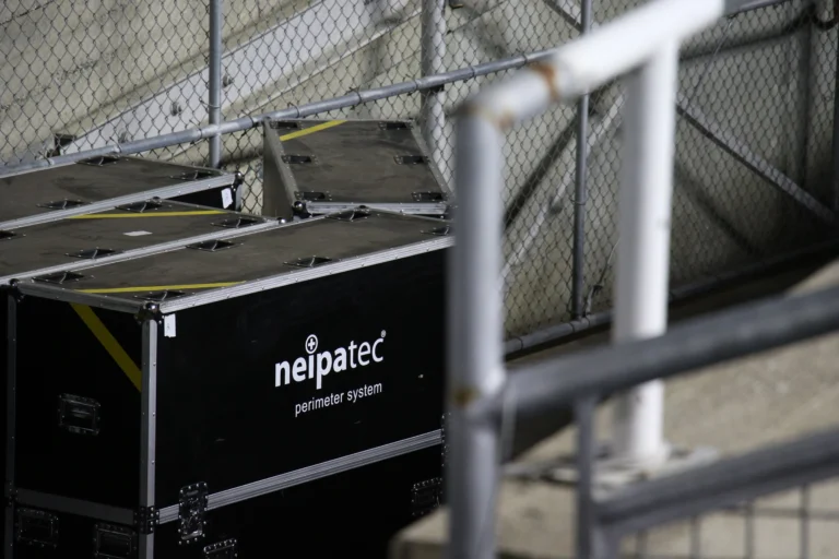 Flight cases for the NEIPATEC perimeter LED system stored behind a stadium fence