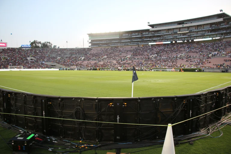 Perimeter LED system seen from behind on match day, filled stands and the corner flag