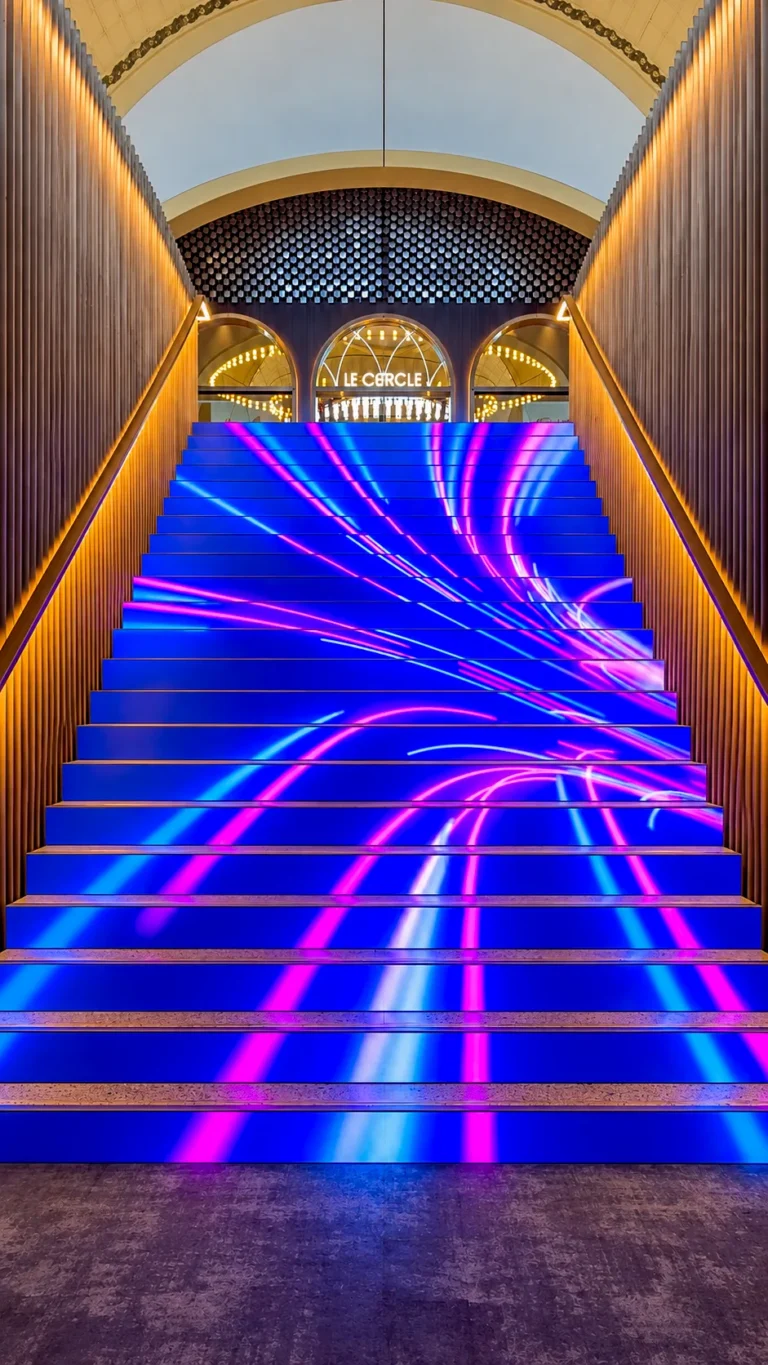 Escalier LED menant au Cercle avec des traînées lumineuses bleues et roses