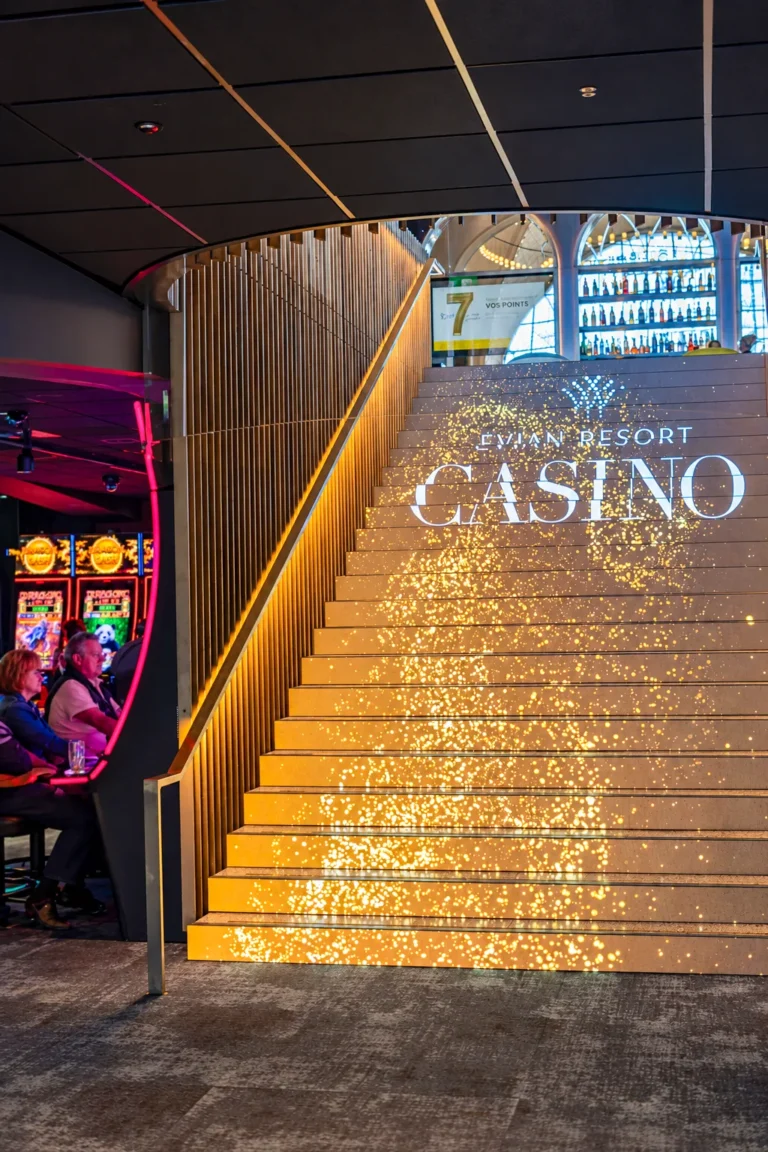 Vue latérale de l’escalier LED doré entre les machines à sous du casino