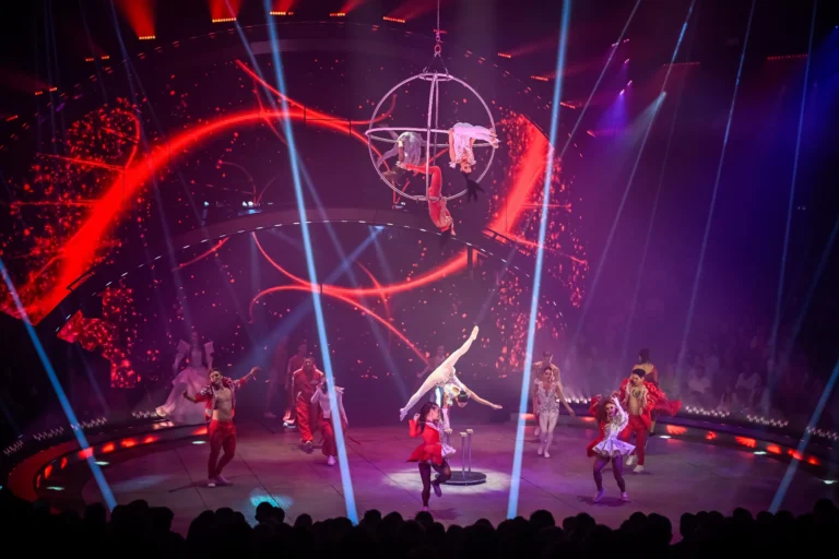 Numéro aérien dans un cerceau devant le fond de scène LED aux visuels rouges du Cirque Knie
