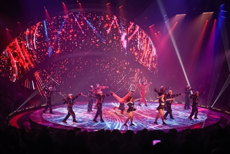 Danseurs sur la piste LED du Cirque Knie, fond de scène LED courbe aux visuels rouges et roses