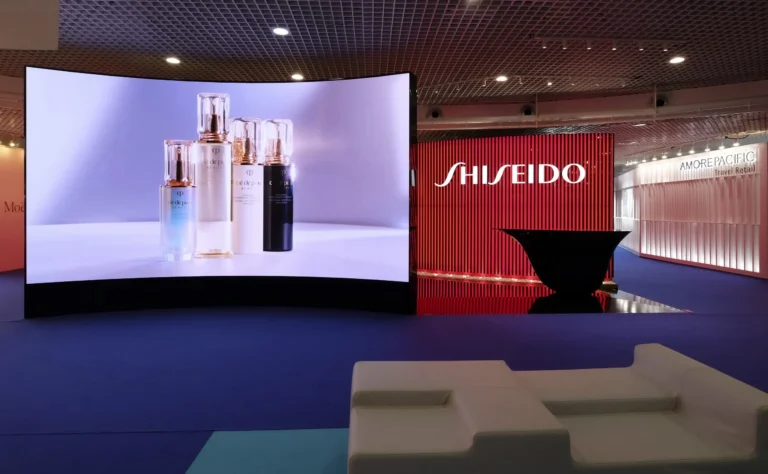 Curved LED screen showing cosmetic products on a Shiseido exhibition stand