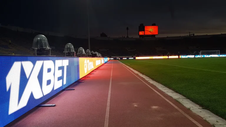 LED perimeter boards along the running track of a stadium at night