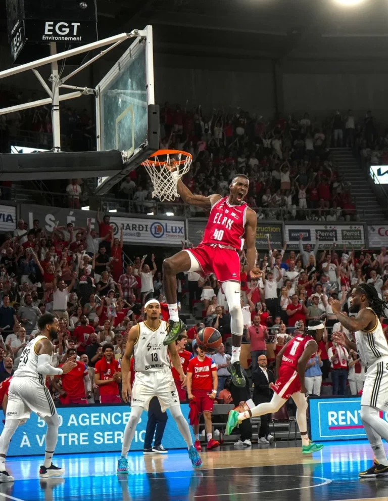 Dunk d’un joueur de l’Élan Chalon devant un public debout, lueur bleue du système LED périmétrique sur le parquet