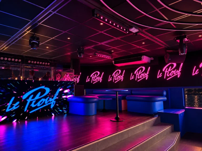 Logo Le Plouf sur l’écran LED de la cabine DJ et en rose sur le mur LED du salon