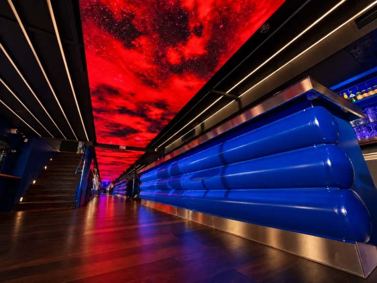 Plafond LED rouge en ciel étoilé au-dessus du comptoir bleu du bar du Plouf