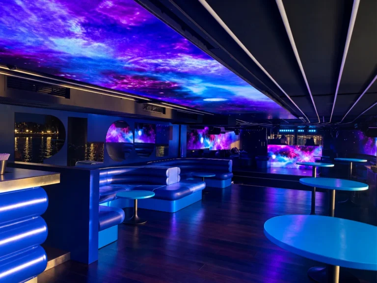 Visuels galaxie sur le plafond et les murs LED du salon, cabine DJ au fond