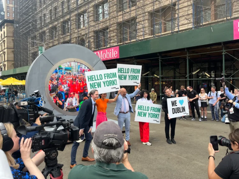 Portail LED circulaire à New York, public muni de pancartes et équipes de tournage au premier plan