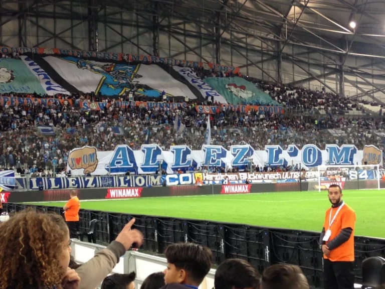 Tifo ALLEZ L’OM déployé dans le virage, système LED périmétrique au bord de la pelouse