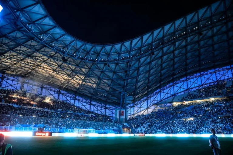 Anneau LED périmétrique illuminant le tour de pelouse du Vélodrome de nuit, toiture bleutée