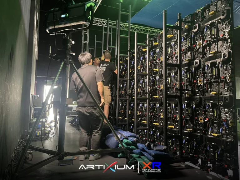 Face arrière des dalles LED et de leur câblage, techniciens au travail dans le studio